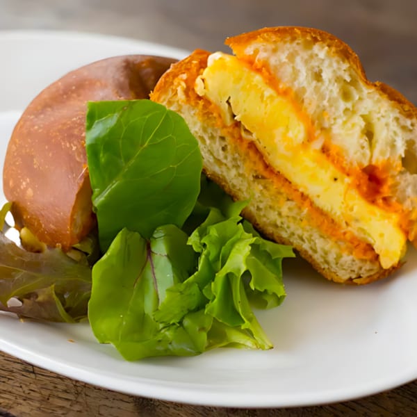 A Roast & Co. breakfast sandwich with egg and cheese, served with a side salad.