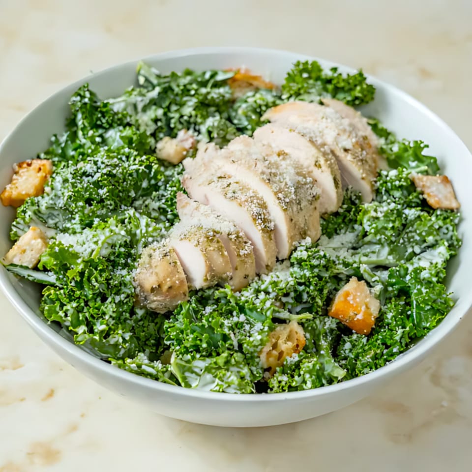 A Roast & Co. kale Caesar salad with sliced chicken, croutons, and parmesan cheese.